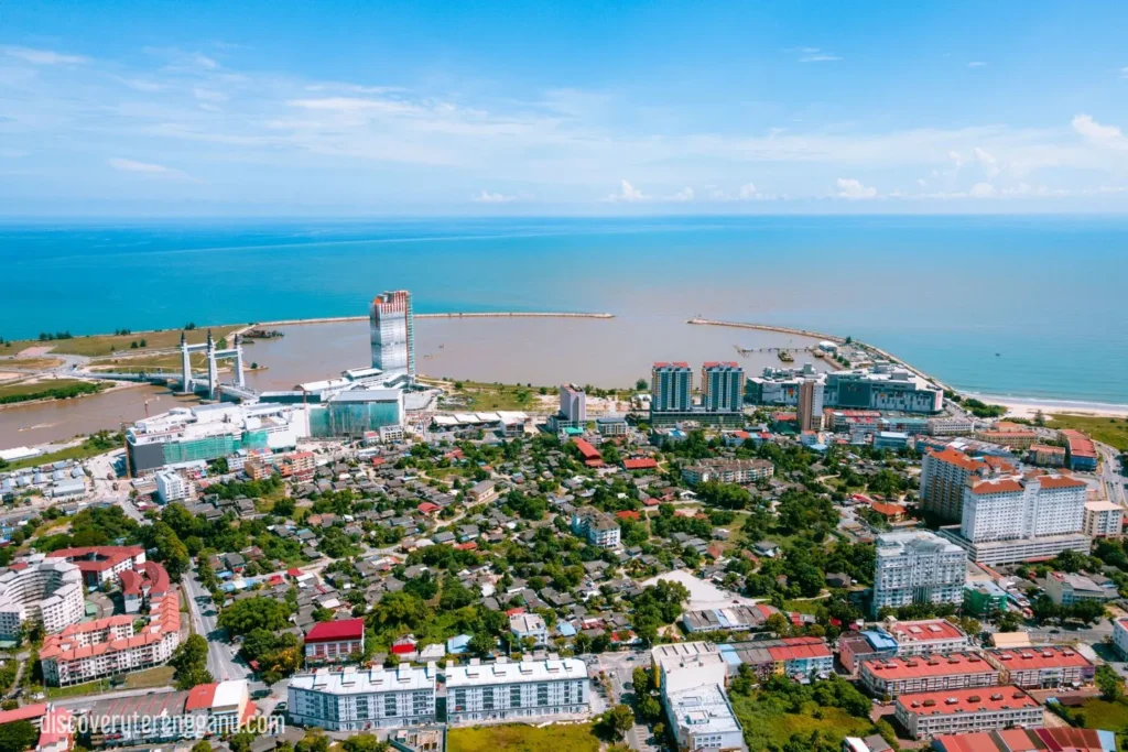 Pandangan udara bandar Kuala Terengganu: Jambatan Angkat dan muara Sungai Terengganu di kiri, menara tinggi, deretan rumah dan pantai menghadap Laut China Selatan