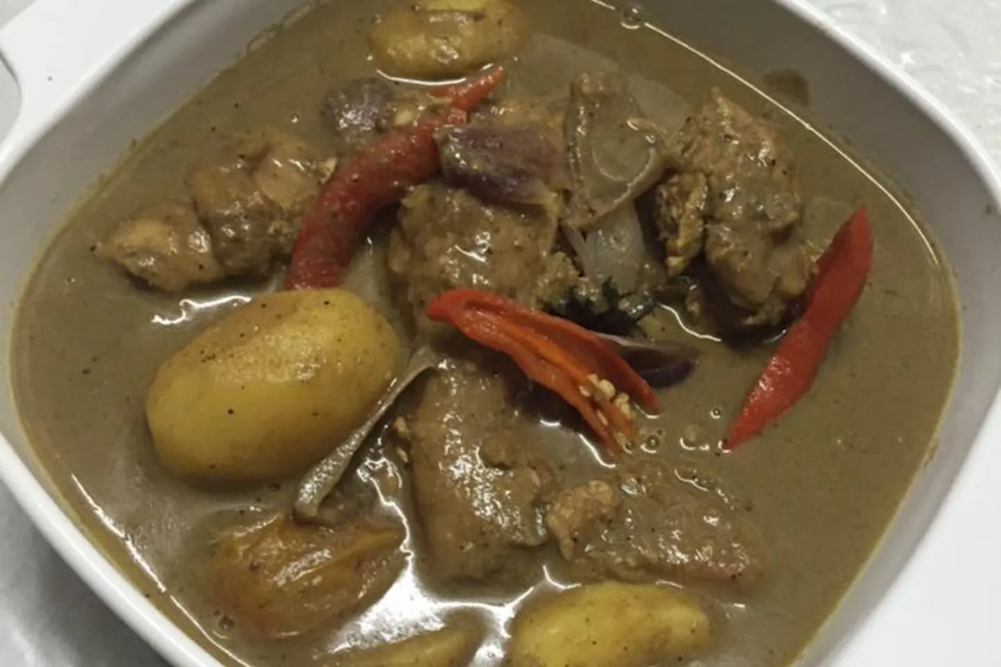 Nasi kuning ayam kurma disusun kemas di atas pinggan