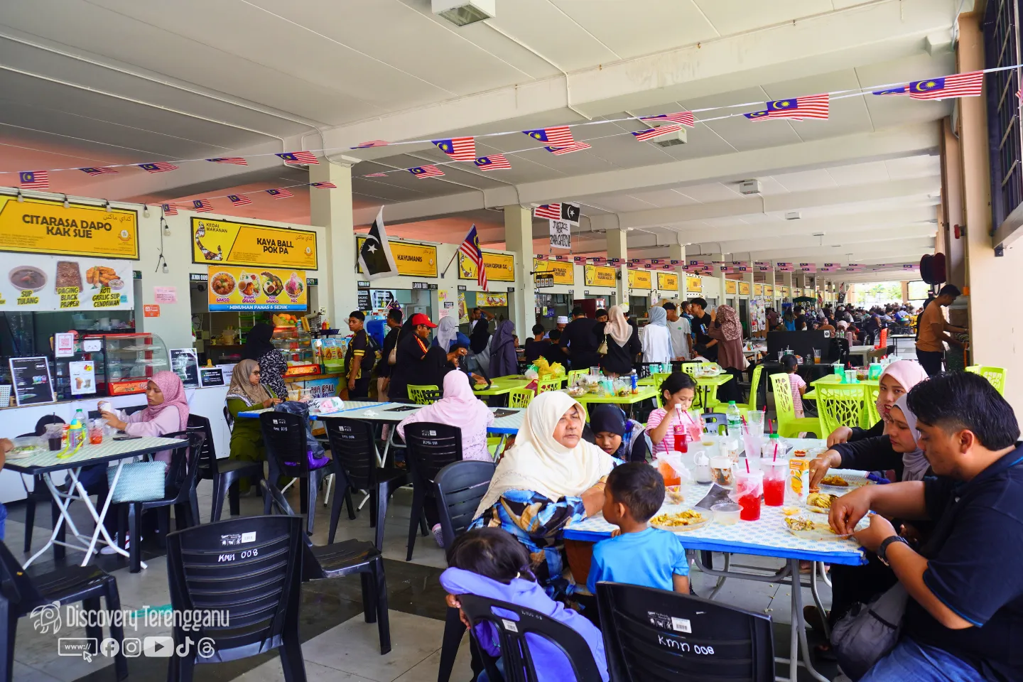 Ruang makan dalam kawasan Pasar Kedai Payang dengan deretan gerai makanan berpapan tanda kuning dan pengunjung makan di meja