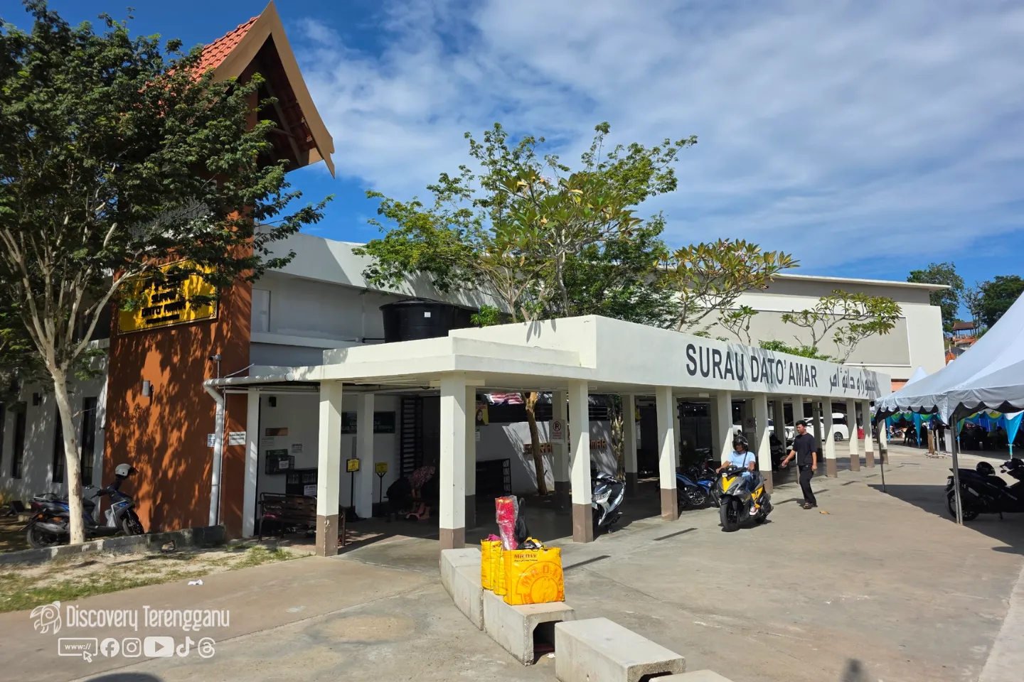 Bangunan surau di kawasan Pasar Payang dengan ruang berbumbung di hadapan, motosikal diletakkan di tepi dan langit cerah
