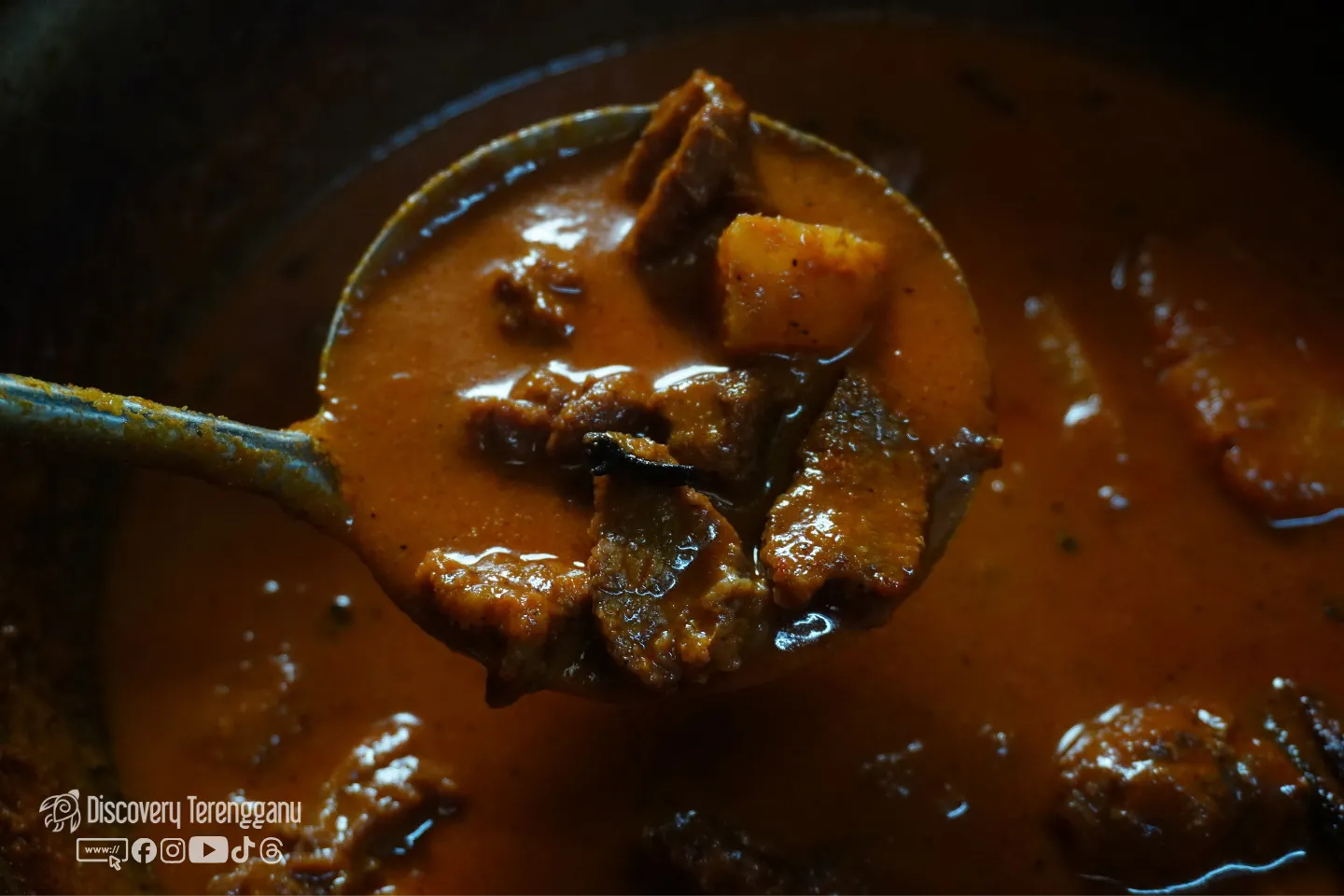 Senduk berisi daging dan nenas dalam kuah pajeri yang berminyak