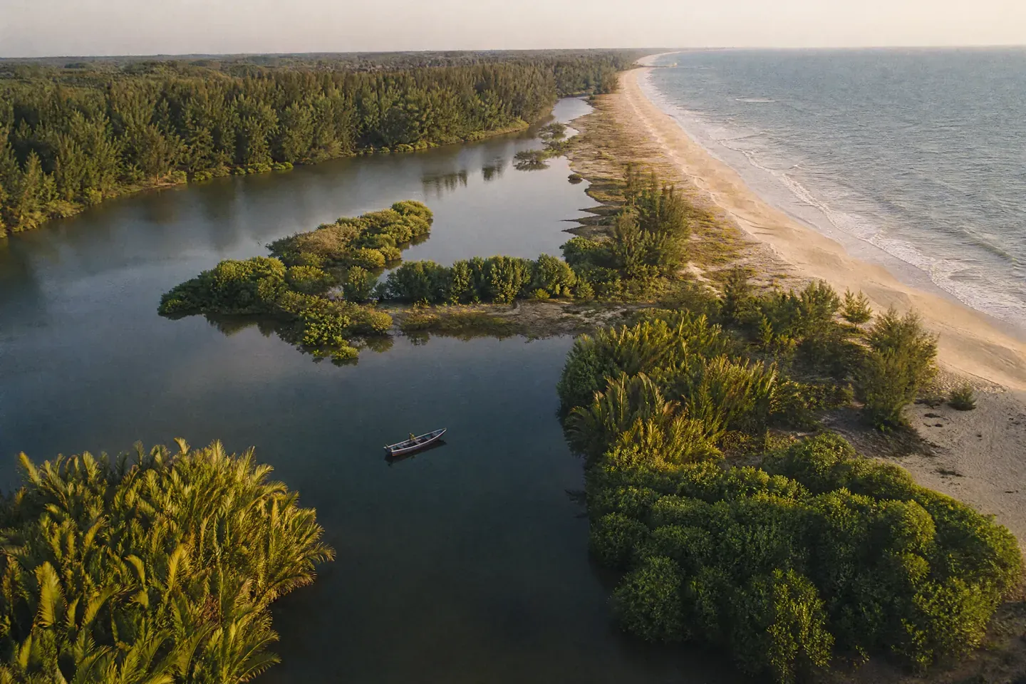 Ilustrasi AI: pandangan udara lagun tenang dengan pokok nipah dan bakau, sebuah perahu kayu kecil serta beting pasir panjang yang memisahkan lagun daripada laut